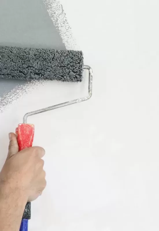 Paint,Roller.,Painting,With,Gray,Paint,Over,A,White,Wall